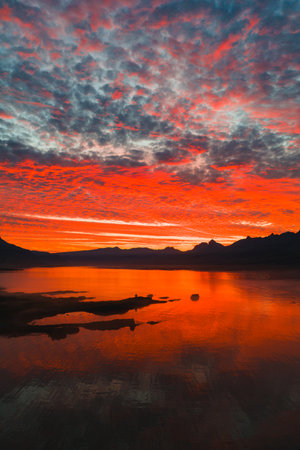 Sunset Over Calm Water with Mountain Silhouettes