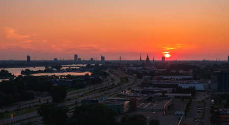 Sunset Over Riga with TV Tower, Old Town Spires, and Daugava Riverの写真素材