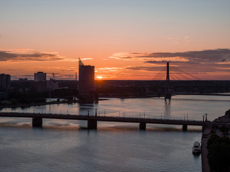 Sunset Over Riga with Daugava River, Bridge, and TV Towerの写真素材