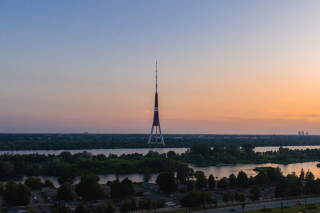 Serene Sunset View of Riga TV Tower and Daugava River in Latviaの写真素材