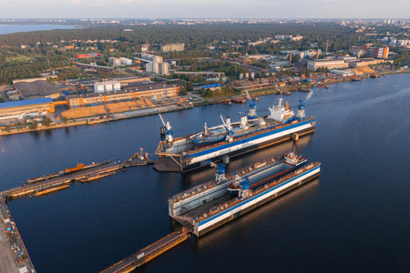 Shipyard with Floating Dry Docks and Riga Cityscape in Sunlight
