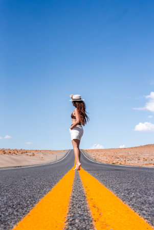 Woman Standing on Centerline of Desert Road in Nevadaの写真素材