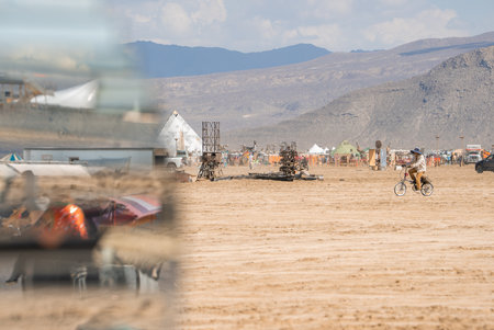 Cyclist in Dusty Terrain at Burning Man Festival, Nevada Desertの写真素材