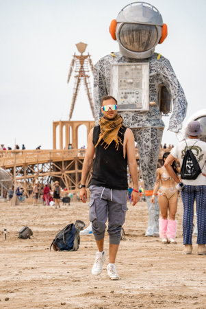 Man Walks Near Astronaut Art and Wooden Man at Burning Manの写真素材