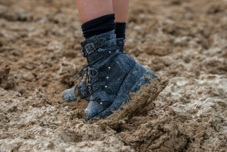 Close Up of Mud Caked Black Boots on Churned Ground at Burning Manの写真素材