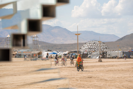 Geodesic Dome and Bicyclists at Burning Man Festival in Nevada Desertの写真素材