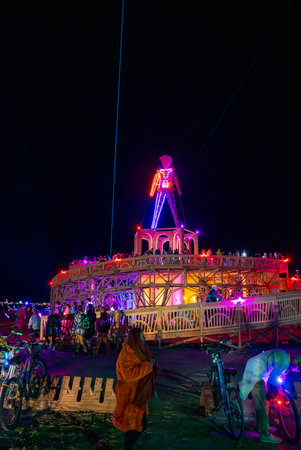 Illuminated Wooden Structure with Neon Effigy at Burning Man 2025の写真素材