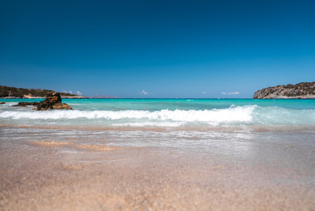 Serene Beach with Turquoise Waters and Rocky Outcrop in Crete, Greeceの写真素材