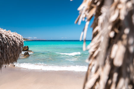 Serene Beach with Turquoise Waters and Straw Parasols in Creteの写真素材