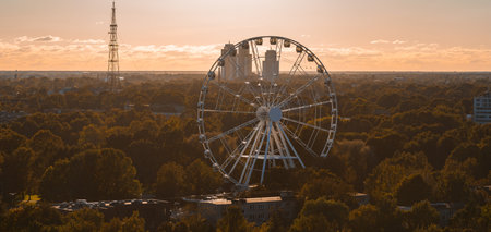 Aerial View of Riga with Ferris Wheel and Urban Landscape at Sunsetの写真素材