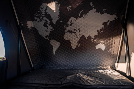Rooftop SUV tent interior with map graphic and warm evening lightの写真素材