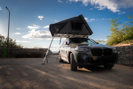 SUV with rooftop tent at ocean seawall in late afternoon lightの写真素材