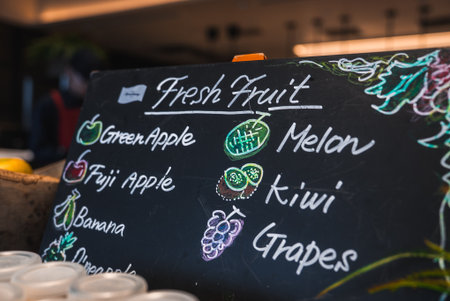 Chalkboard fresh fruit menu at hotel cafe with cups and warm lighting