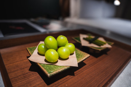 Close up of wooden tray with grapes and green sweetsの写真素材