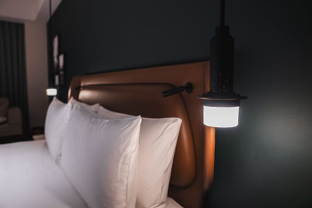 Luxury hotel bedroom close up with white pillows and pendant lampの写真素材