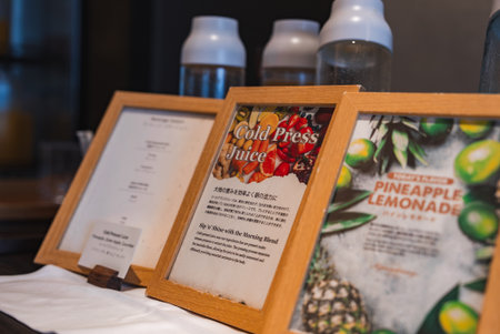 Hotel cafe countertop display with bilingual juice menus and bottlesの写真素材