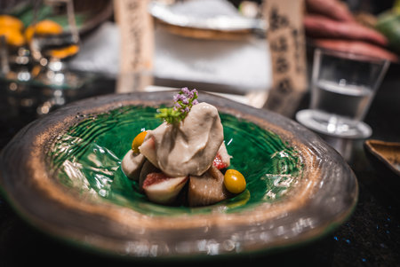 Close up of kaiseki dish with figs and ginkgo on green ceramic plateの写真素材