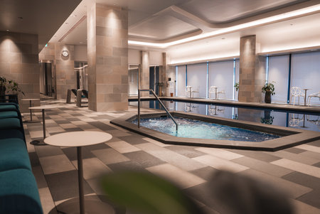 Modern indoor spa with hexagonal hot tub and lap pool in Japan