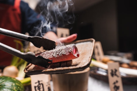 Chef lifts steaming seared tuna or wagyu at luxury Japan buffetの写真素材