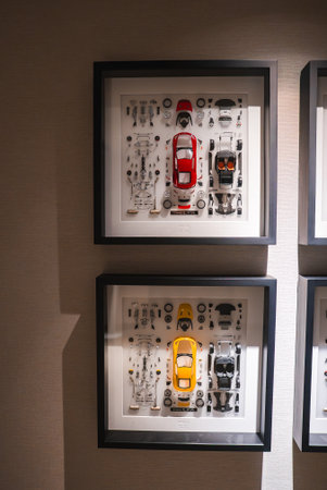 Model car components arranged in shadow boxes on a gallery wall