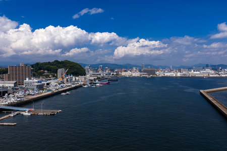 Hiroshima waterfront harbor with marina, breakwater, and hillsの写真素材