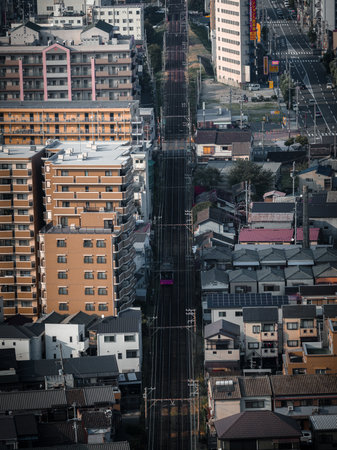 Aerial telephoto view of Osaka tram line through dense housingの写真素材