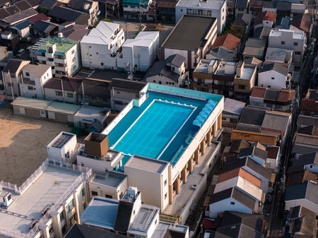 Aerial view of rooftop pool in compact Osaka neighborhood at duskの写真素材