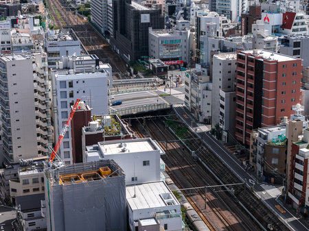 Aerial view of Tokyo rail lines, overpass, and urban constructionの写真素材