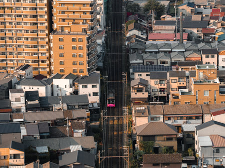 Aerial view of Osaka tram on straight tracks through compact housingの写真素材