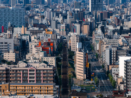 Daytime view of central Osaka with rail corridor and dense towersの写真素材