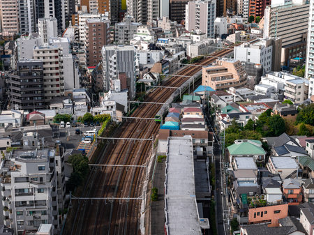 Aerial urban rail corridor through Tokyo neighborhoods with mid risesの写真素材