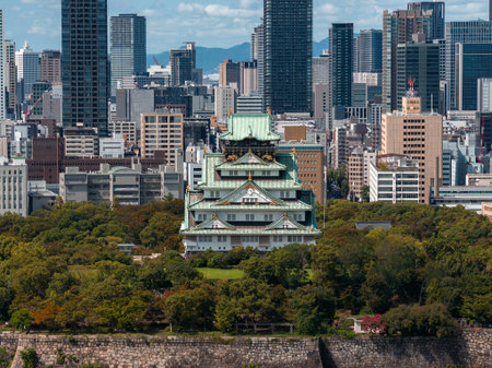 Aerial view of Osaka Castle amid Osaka skyline and distant mountainsの写真素材