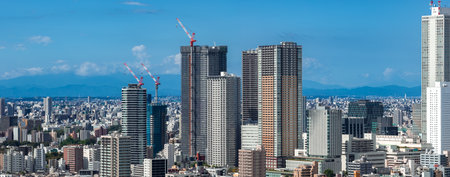 Aerial panoramic view of central Tokyo towers and cranes in daylightの写真素材