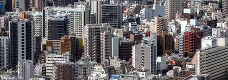 Central Tokyo mid and high rise blocks with rail tracks and craneの写真素材