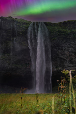 Seljalandsfoss waterfall at night with aurora in South Icelandの写真素材