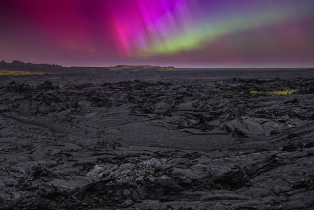 Aurora borealis over lava field on Icelandic volcanic plain at nightの写真素材