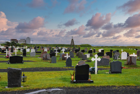 Coastal cemetery at sunset with crosses and granite headstones in Iceland