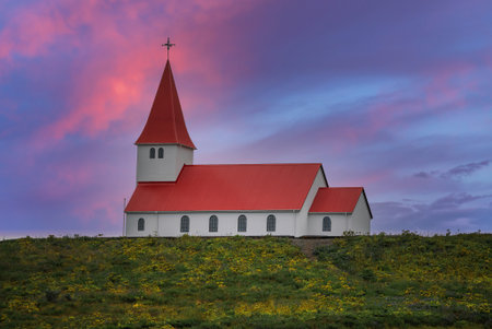 White church with red roof on hill at summer sunset in Vik, Icelandの写真素材