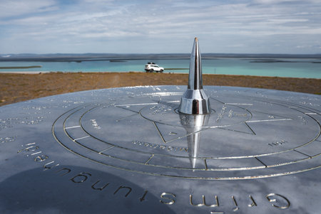 Compass table and lagoon with white 4x4 under soft lightの写真素材