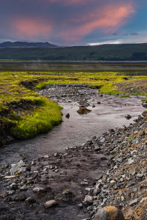 Rocky stream and calm lake in Icelandic highlands at sunsetの写真素材