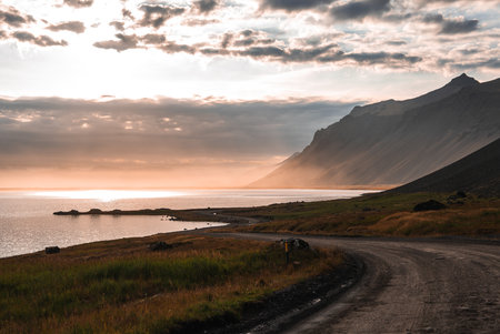 Gravel road along Eastfjords near Vestrahorn at golden sunsetの写真素材