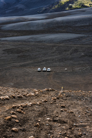 Icelandic highland desert with 4x4 vehicles on black volcanic sandの写真素材