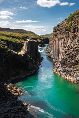 Turquoise river in Studlagil Canyon with hexagonal basalt wallsの写真素材
