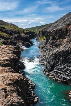 Turquoise river in Studlagil Canyon with basalt columns, Iceland