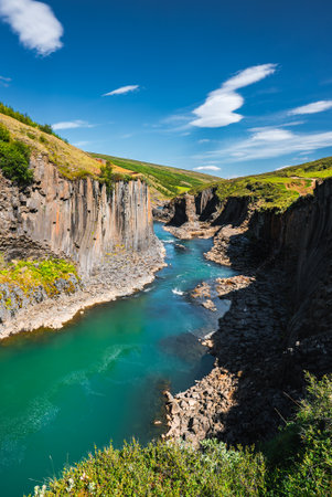 Turquoise river threads through Studlagil Canyon basalt columns, Icelandの写真素材