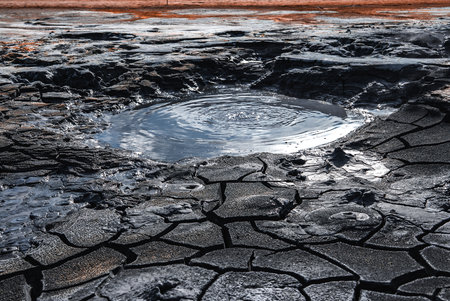 Geothermal mud pool ripples in cracked crust at Hverir, Iceland