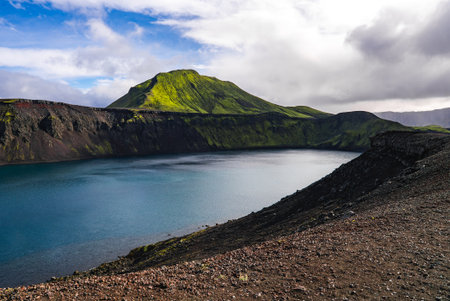 Volcanic crater lake and mossy mountain in Icelandic highlandsの写真素材