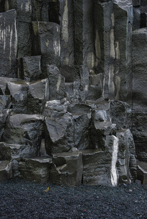 Basalt columns at Reynisfjara rise above black sand in Iceland