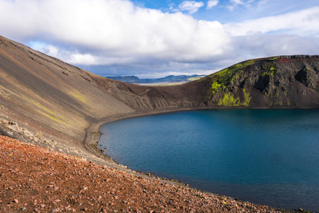 Turquoise crater lake in ash gray caldera with moss in Icelandの写真素材