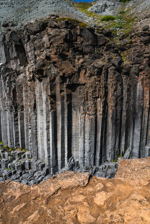 Hexagonal basalt columns and mossy slope in daylight, Icelandの写真素材
